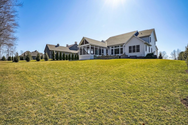 back of property with a yard and a sunroom