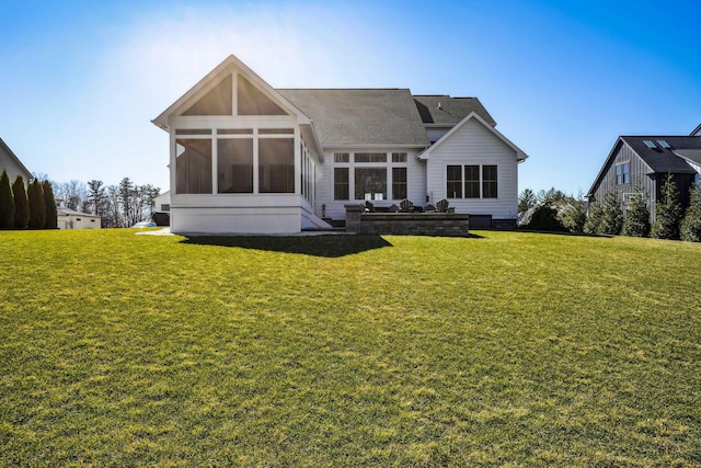 rear view of house featuring a yard and a sunroom