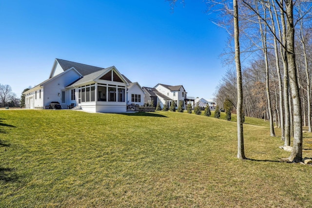 view of yard featuring a garage and a sunroom