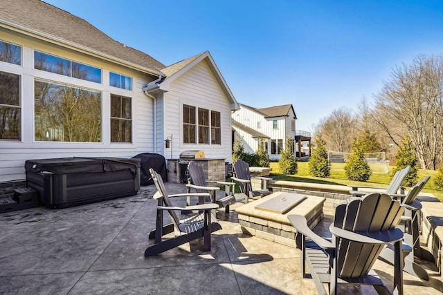 view of patio / terrace featuring area for grilling, a fire pit, and a hot tub