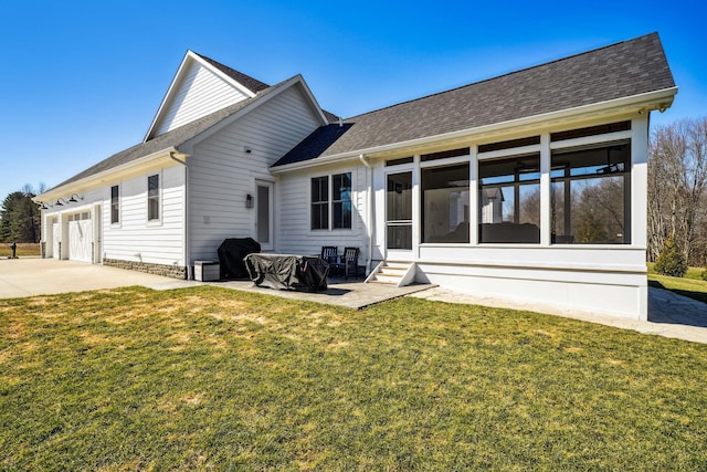 rear view of property featuring a shingled roof, concrete driveway, a yard, and a sunroom