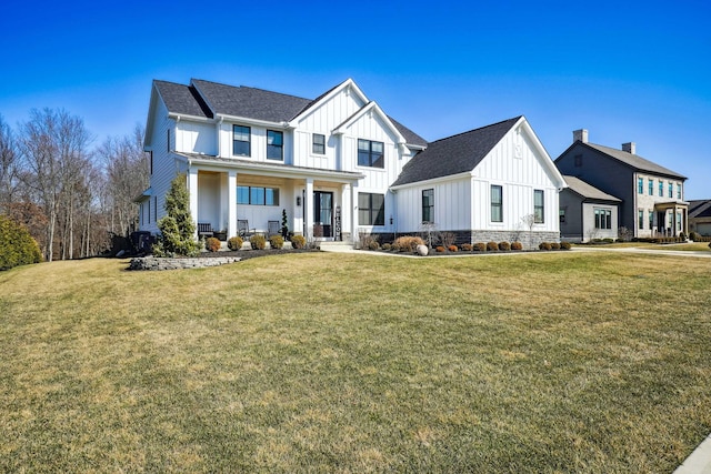 modern farmhouse style home featuring board and batten siding, a front yard, and a shingled roof