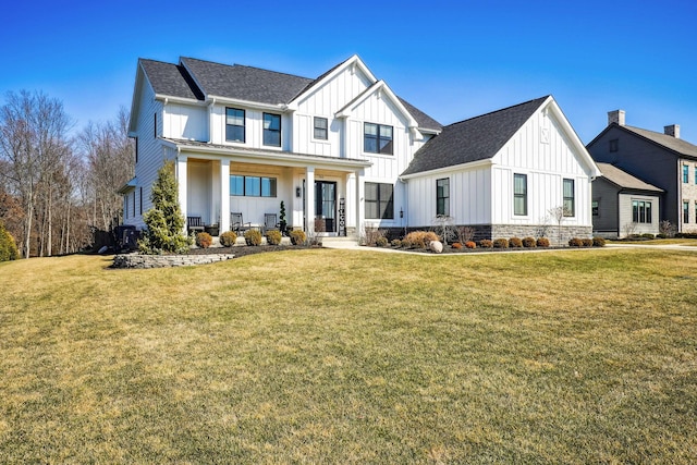 modern farmhouse featuring a front lawn, board and batten siding, and a shingled roof