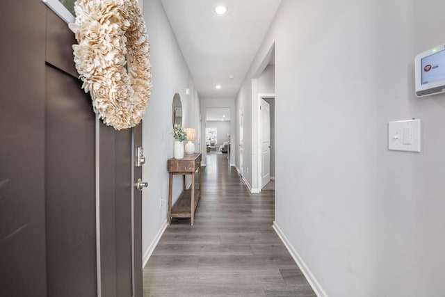 corridor featuring recessed lighting, wood finished floors, baseboards, and arched walkways