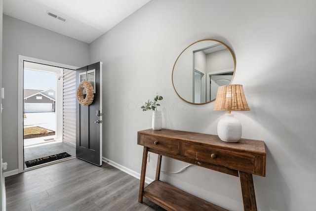 entrance foyer with wood finished floors, visible vents, and baseboards