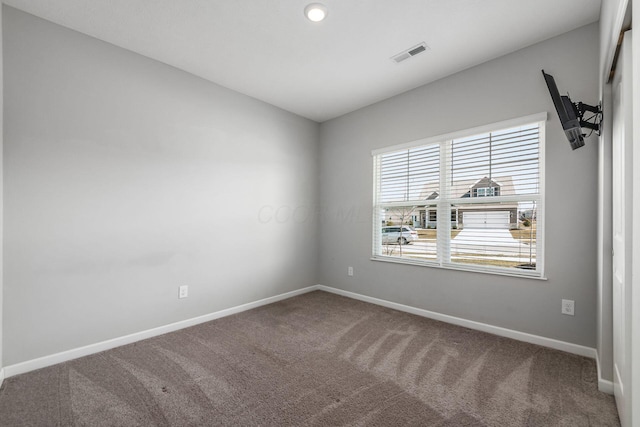 carpeted empty room with visible vents and baseboards