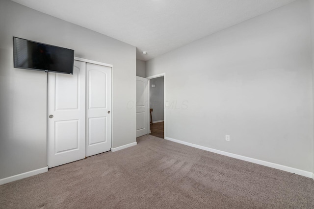 unfurnished bedroom with carpet flooring, baseboards, and a closet