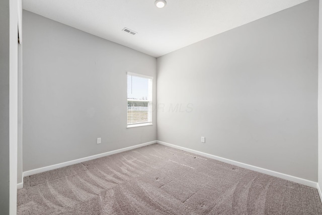 carpeted empty room featuring visible vents and baseboards