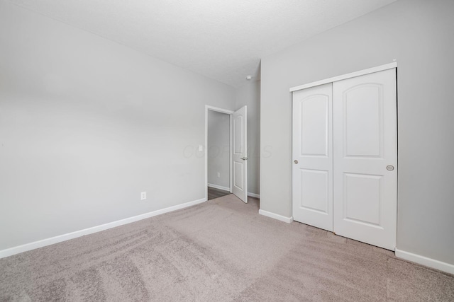 unfurnished bedroom featuring a closet, baseboards, carpet, and a textured ceiling