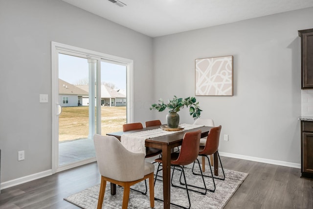 dining room featuring baseboards and dark wood finished floors