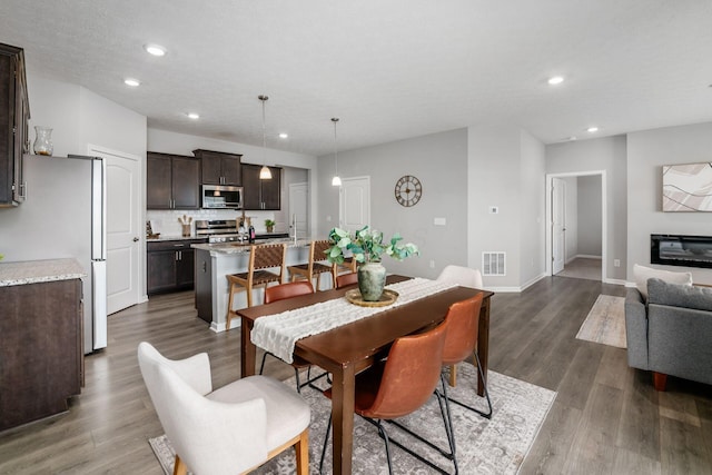 dining space with visible vents, recessed lighting, baseboards, and dark wood-style flooring