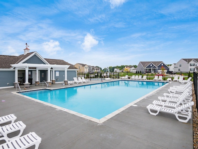 pool featuring a residential view, a patio, and fence