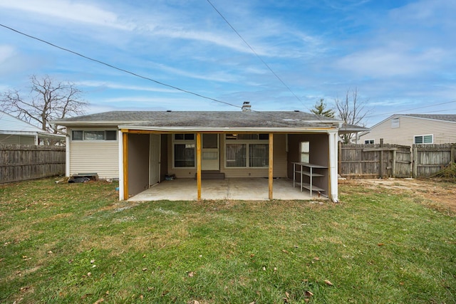 back of house with a fenced backyard, a lawn, and a patio