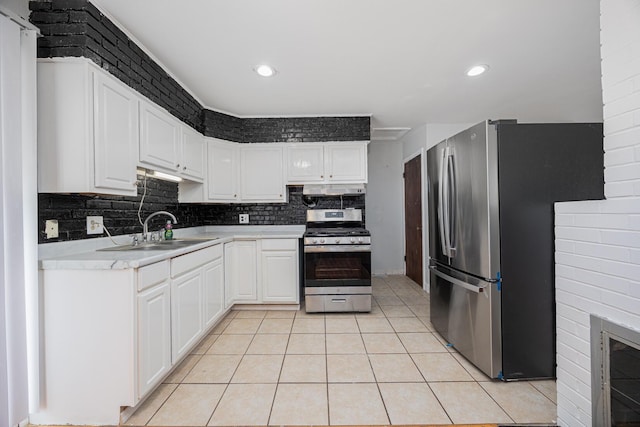 kitchen featuring tasteful backsplash, light tile patterned floors, white cabinets, stainless steel appliances, and a sink