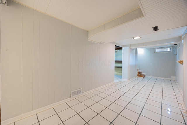 empty room with light tile patterned floors, visible vents, and wooden ceiling