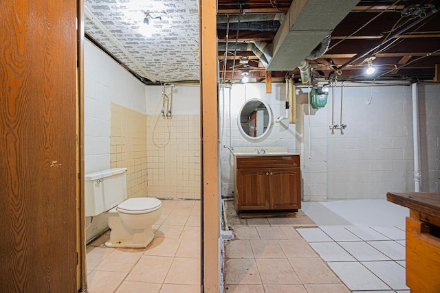 bathroom with a tile shower, tile patterned floors, toilet, and vanity