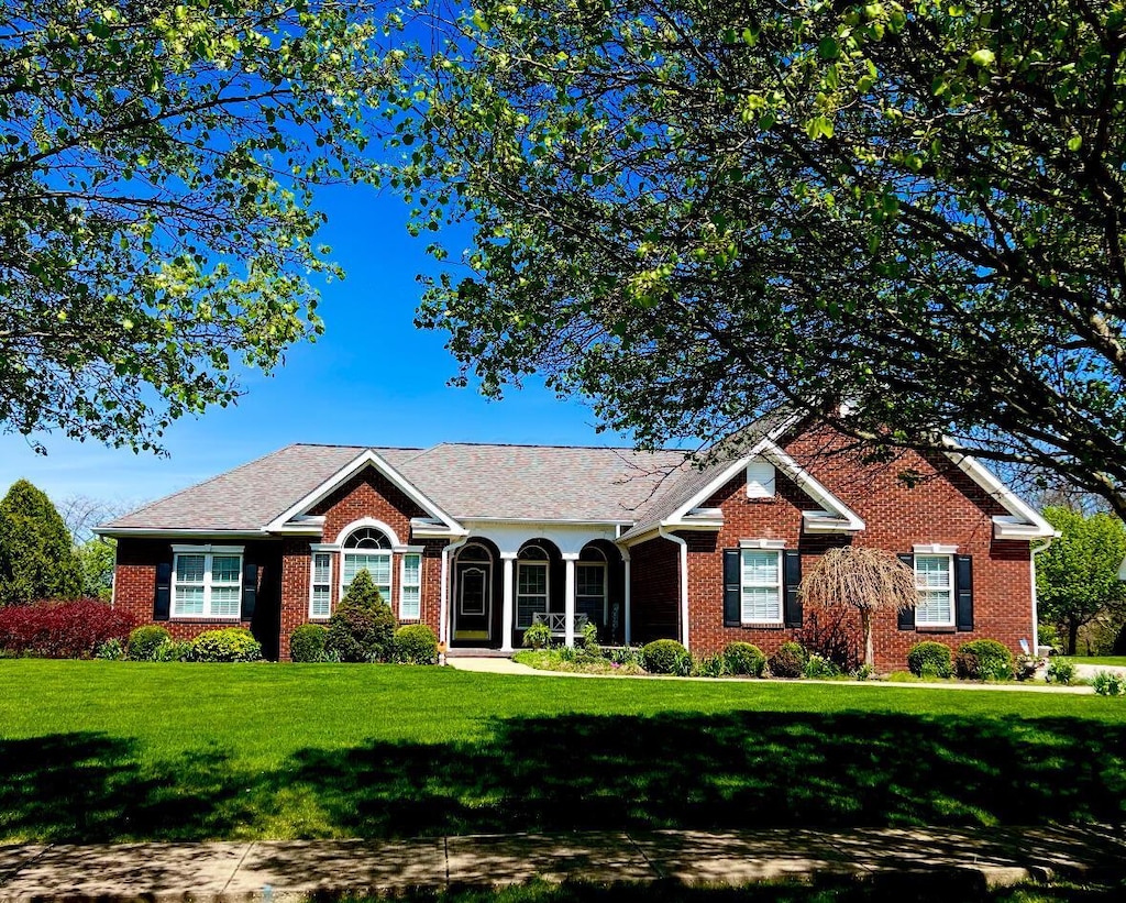 single story home featuring brick siding and a front lawn