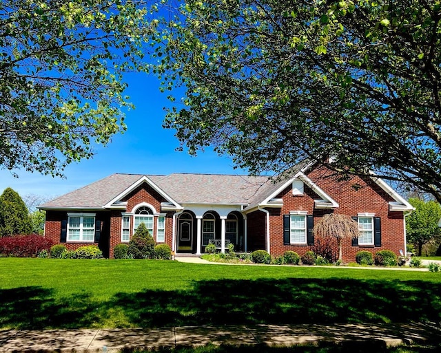 ranch-style house featuring brick siding and a front yard