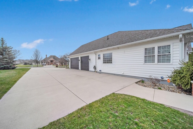 exterior space featuring a lawn, concrete driveway, and a shingled roof
