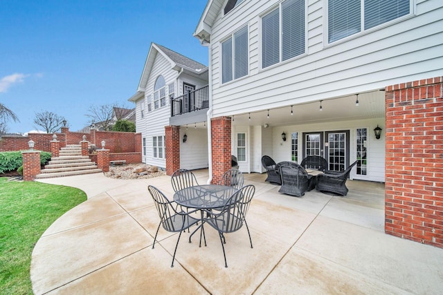 view of patio with outdoor dining space and a balcony