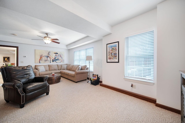 living area with baseboards, a ceiling fan, a raised ceiling, and carpet flooring