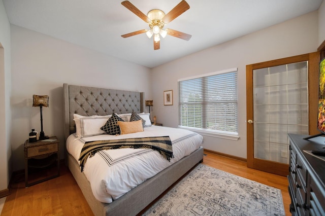 bedroom featuring ceiling fan, baseboards, and light wood-style floors