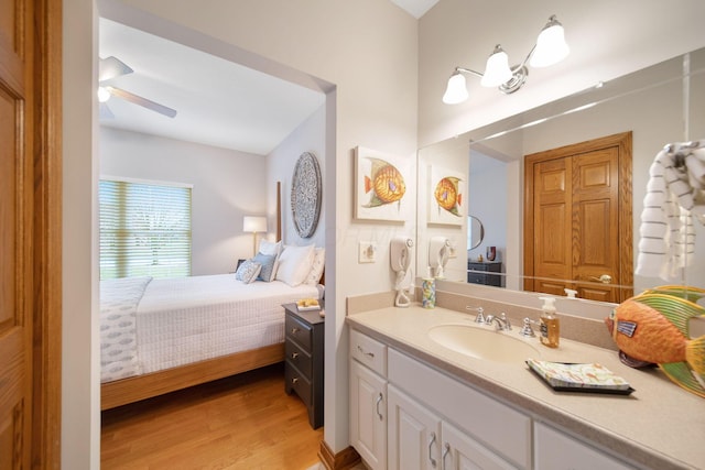 bathroom featuring vanity, ensuite bath, wood finished floors, and a ceiling fan