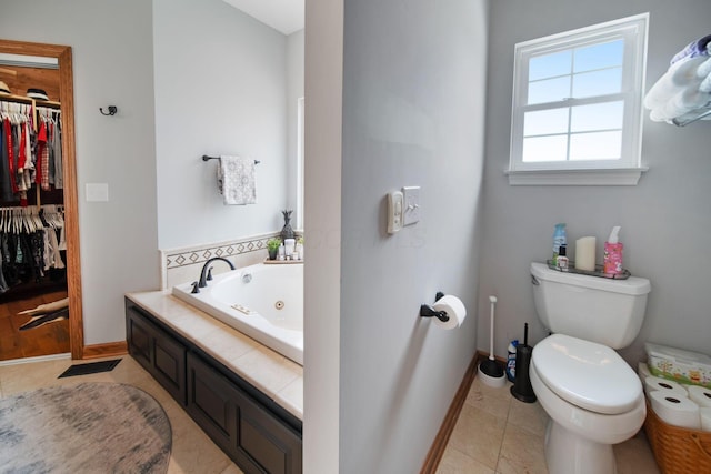 full bath with baseboards, tile patterned flooring, a spacious closet, a jetted tub, and toilet