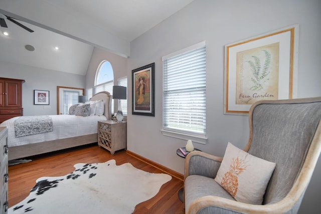 bedroom featuring baseboards, wood finished floors, and vaulted ceiling