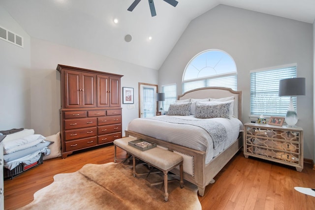 bedroom featuring ceiling fan, visible vents, light wood-type flooring, and high vaulted ceiling