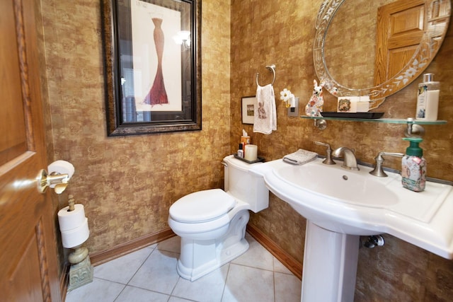 half bath featuring baseboards, toilet, and tile patterned flooring