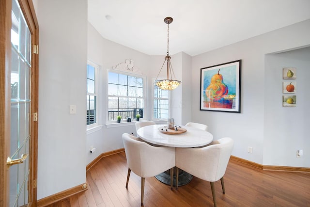 dining space with baseboards and wood finished floors