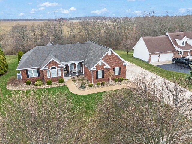 view of front of home featuring a front yard, a garage, brick siding, and driveway