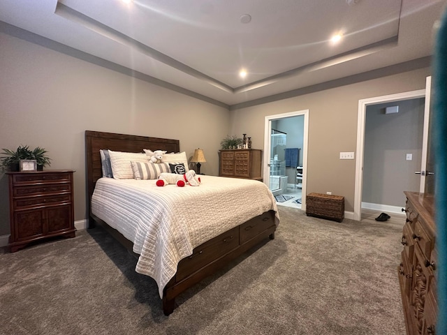 bedroom featuring a tray ceiling, baseboards, ensuite bath, and carpet flooring