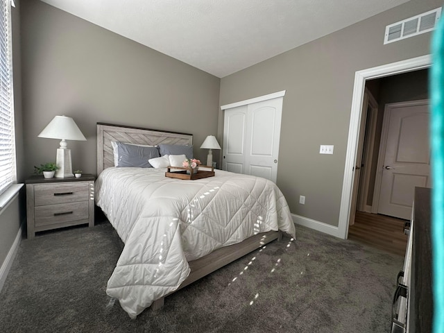 bedroom with carpet flooring, baseboards, visible vents, and a closet