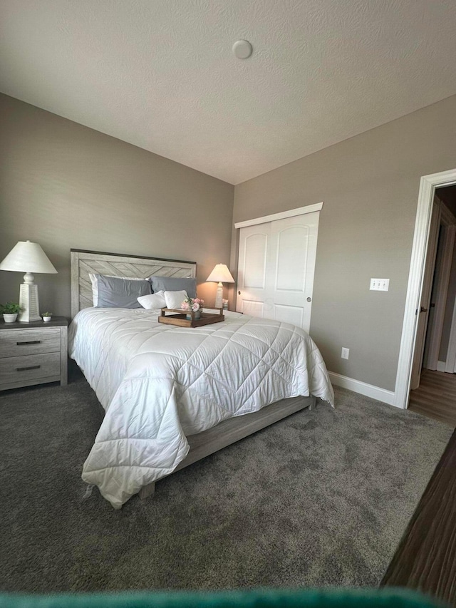 bedroom featuring a closet, a textured ceiling, baseboards, and carpet floors