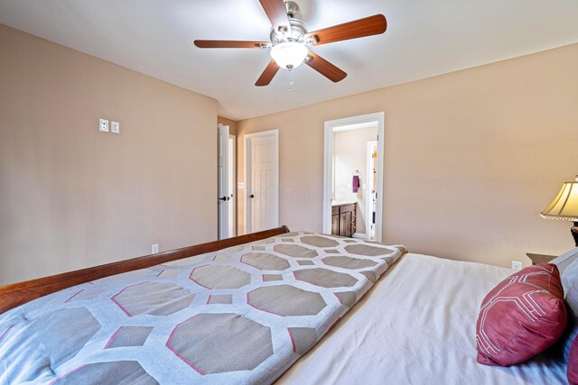 bedroom featuring ensuite bath, a ceiling fan, and baseboards