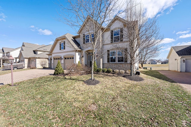 view of front of house with decorative driveway, stone siding, and a front yard