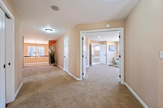 corridor with baseboards and carpet