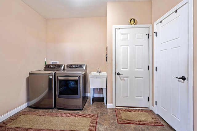 washroom featuring baseboards, laundry area, and washing machine and clothes dryer