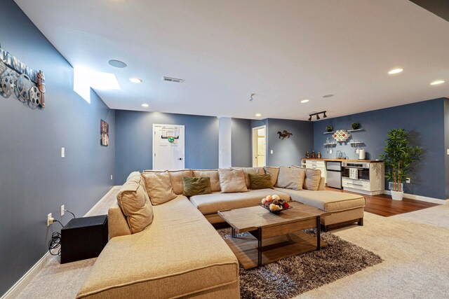 living room with baseboards, visible vents, a bar, and carpet