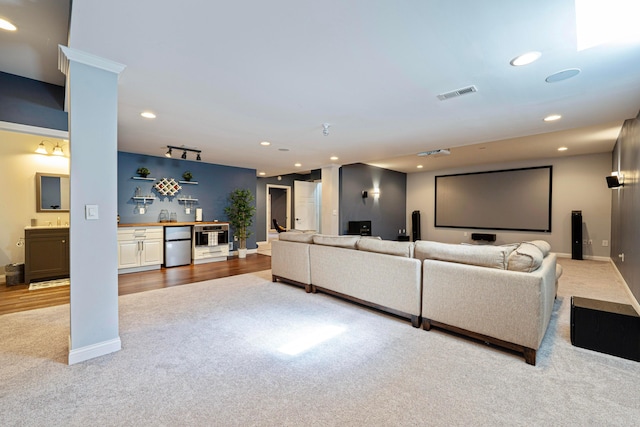 carpeted cinema featuring visible vents, baseboards, indoor wet bar, recessed lighting, and rail lighting