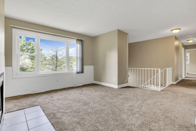 unfurnished living room featuring carpet floors and baseboards
