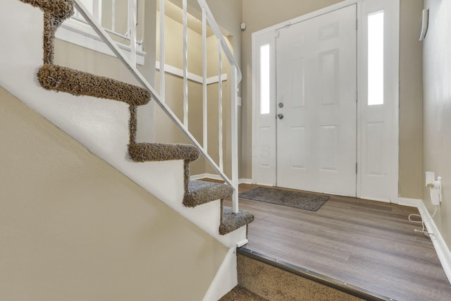 entrance foyer featuring stairway, baseboards, wood finished floors, and healthy amount of natural light