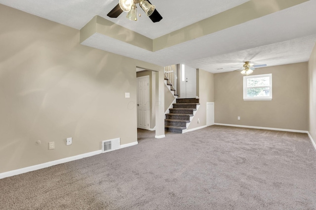 below grade area featuring ceiling fan, baseboards, and carpet