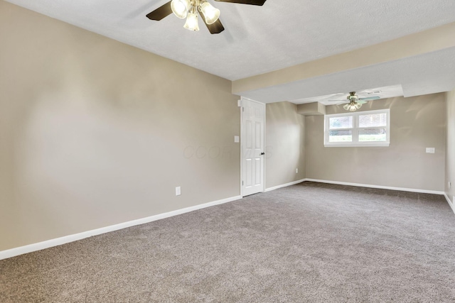 spare room featuring ceiling fan, dark carpet, and baseboards