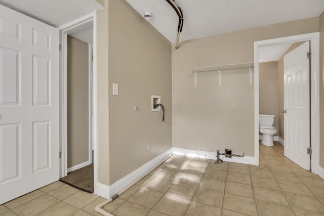 clothes washing area featuring light tile patterned floors, hookup for a washing machine, and baseboards