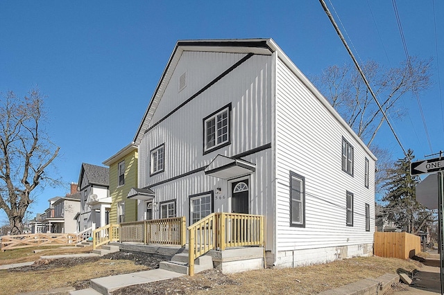 view of front of house with a residential view and fence