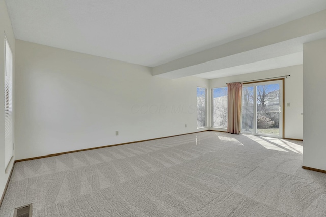 unfurnished room with light colored carpet, visible vents, and baseboards