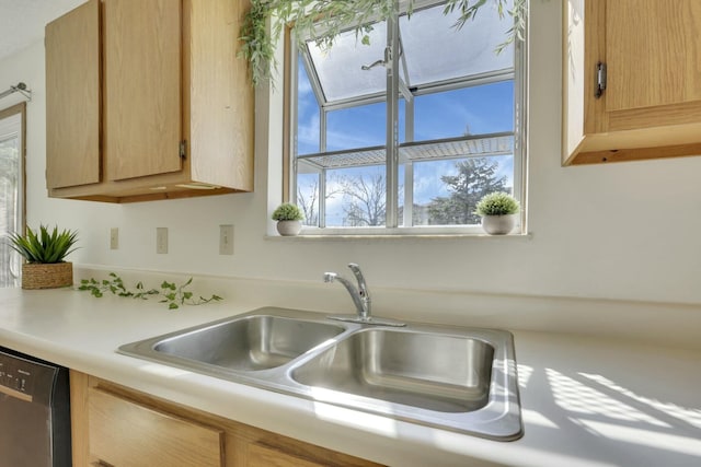 kitchen with a sink, dishwasher, light brown cabinetry, and light countertops